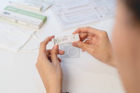 Foto de Primer plano de la persona que lee el kit de prueba de coronavirus resultado en casa - Imagen libre de derechos