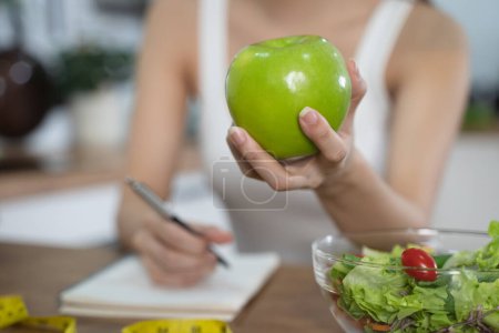 Téléchargez les photos : Personne prendre note du poids et le comptage des calories à manger dans ea - en image libre de droit