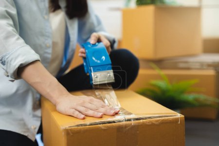 Foto de Cerrar la cinta de sellado de la persona en la caja de paquete prepararse para el servicio de entrega para recoger. - Imagen libre de derechos