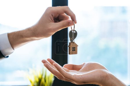 Téléchargez les photos : Close up view hand of property realtor landlord giving key house to buyer tenant. - en image libre de droit