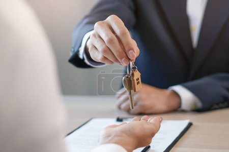 Foto de Close up view hand of property realtor / landlord giving key house to buyer / tenant. - Imagen libre de derechos