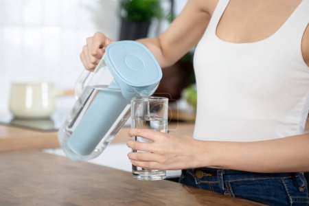 Téléchargez les photos : Close up female pouring water to glass for drink - en image libre de droit