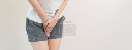 Téléchargez les photos : Femme ayant mal au bas de l'estomac et les mains tenant appuyant sur son abdomen inférieur de l'entrejambe - en image libre de droit