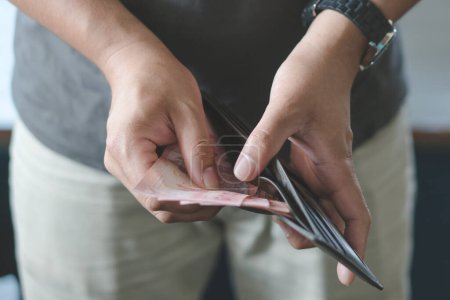 Téléchargez les photos : Man holding wallet with full of money prepare for spend. - en image libre de droit