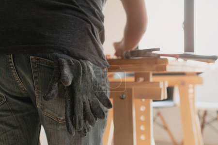 Photo for Back view of craftsman working in studio. selective focus on gloves. - Royalty Free Image