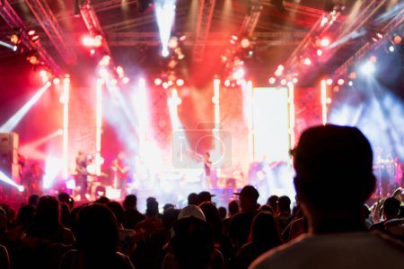 Téléchargez les photos : Silhouettes de concert et de foule devant les lumières de la scène et les gens flous sur scène. - en image libre de droit