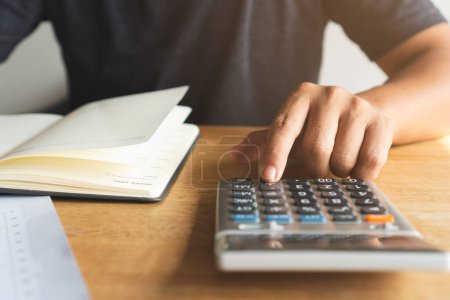 Foto de Las manos de la persona que usa la calculadora se preparan para el impuesto anual. - Imagen libre de derechos