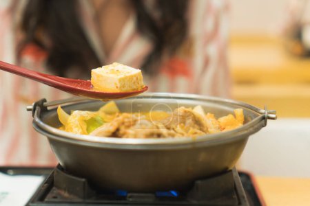 Photo for Woman enjoying eat homemade hot pot with family in holidays. - Royalty Free Image