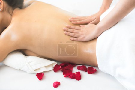 Téléchargez les photos : Young woman enjoying with oil body massage thai style in spa salon on holiday. selective focus on hands of masseur. - en image libre de droit