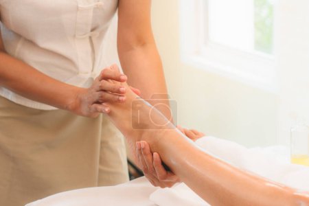 Téléchargez les photos : Détendez-vous avec un massage à l'huile aromatique dans le salon de spa. femme couchée sur le lit relaxant avec massage des pieds pendant le traitement dans le spa de beauté. - en image libre de droit