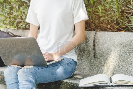 Téléchargez les photos : University student using internet search data for doing homework from computer in campus. - en image libre de droit