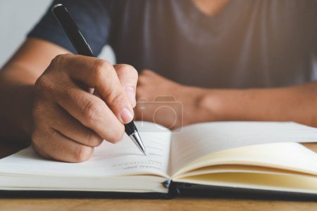 Téléchargez les photos : Gros plan de la main de l'étudiant écrivant des notes dans le carnet
. - en image libre de droit