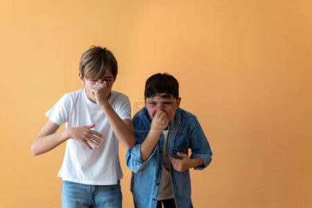 Two children hold their noses due to bad odor