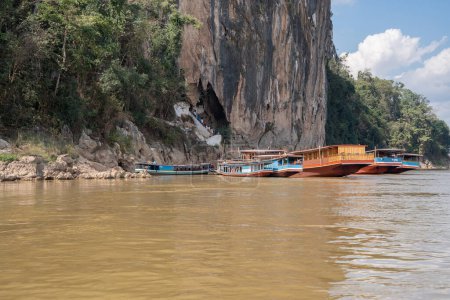 Téléchargez les photos : Bateaux en bois laotiens sur le Mékong en face de la grotte de Pak Ou à Luang Prabang au Laos Asie - en image libre de droit