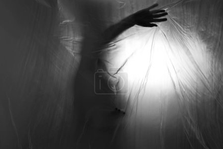 Téléchargez les photos : Silhouette derrière rideau en plastique. anxiété sociale, dépression, concept d'isolement - en image libre de droit