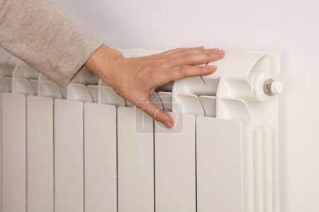 Photo for Woman touching cold radiator close up. Global energy crisis concept. Household energy saving - Royalty Free Image