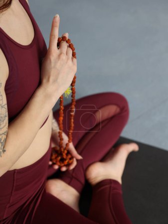 Eine Frau hält Rosenkranzperlen in Nahaufnahme. Yoga, Meditation, ganzheitliches Wellness-Konzept.