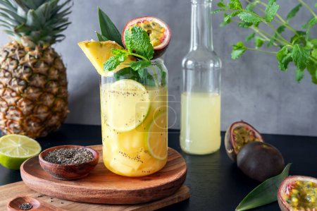 Tropical pineapple cocktail with passion fruit or maracuya and chia seeds topped with fruit, mocktail.