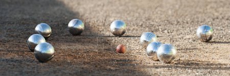 Photo for Petanque balls boules bowls on closeup on sand gravel court background, game of petanque on the ground. Balls and a small wood jack - Royalty Free Image
