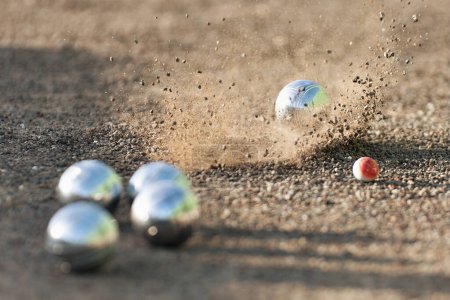 Photo for Petanque ball boules bowls on a dust floor, photo in impact. Game of petanque on the ground. Balls and a small wood jack - Royalty Free Image
