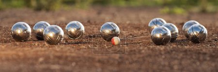 Photo for Petanque balls boules bowls on closeup on sand gravel court background, game of petanque on the ground. Balls and a small wood jack - Royalty Free Image