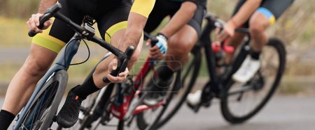 Foto de Competencia ciclista, atletas ciclistas montando una carrera a alta velocidad. Inclinado en una esquina. Centrado en los zapatos de ciclismo - Imagen libre de derechos