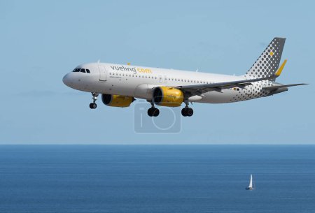 Téléchargez les photos : Tenerife, Espagne 4 juin 2023. Vueling Airlines Airbus a320 Atterrissage à l'aéroport international de Tenerife. Vueling Airlines vole dans le ciel bleu au-dessus de l'océan - en image libre de droit