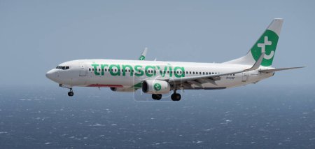 Téléchargez les photos : Tenerife, Espagne 2 août 2023. Boeing 737 de Transavia Airlines vole dans le ciel bleu au-dessus de l'océan - en image libre de droit