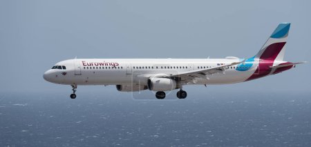 Téléchargez les photos : Tenerife, Espagne 2 août 2023. AIRBUS A321 d'EUROWINGS Airlines vole dans le ciel bleu au-dessus de l'océan - en image libre de droit