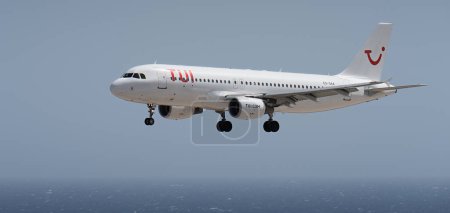 Téléchargez les photos : Tenerife, Espagne 2 août 2023. Airbus A320-200 de Tui Airlines vole dans le ciel bleu au-dessus de l'océan - en image libre de droit