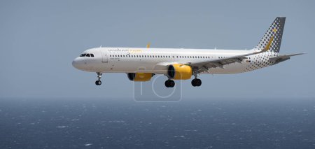 Téléchargez les photos : Tenerife, Espagne 2 août 2023. Airbus A321neo de Vueling Airlines vole dans le ciel bleu au-dessus de l'océan - en image libre de droit