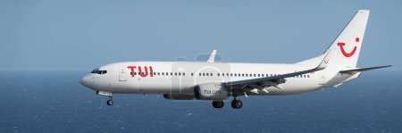Téléchargez les photos : Tenerife, Espagne 4 août 2023. Boeing 737-8AS de Tui Airlines vole dans le ciel bleu au-dessus de l'océan - en image libre de droit