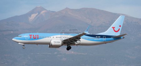 Foto de Tenerife, España 13 de enero de 2024.Boeing 737 MAX 8 TUI Airlines vuela en el cielo azul. Aterrizaje en el aeropuerto de Tenerife. Volcán El Teide en el fondo - Imagen libre de derechos