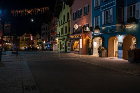 Foto de KITZBUHEL, AUSTRIA - JANUARY 07, 2023: Night view of Kitzbuhel, a small Alpine town. Upscale shops and cafes line the streets of its medieval center. - Imagen libre de derechos