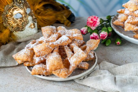 Buñuelos de carnaval italianos tradicionales espolvoreados con azúcar en polvo - frappe o chiacchiere
