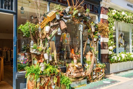 Foto de LONDRES, Reino Unido - 24 de mayo de 2023: Una exhibición floral decora la ventana de una tienda en Chelsea durante la exposición anual de arte floral Chelsea in Bloom en Londres - Imagen libre de derechos