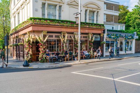 Foto de LONDRES, Reino Unido - 24 de mayo de 2023: Exposiciones florales decoran escaparates en Chelsea durante la exposición anual de arte floral Chelsea in Bloom en Londres - Imagen libre de derechos