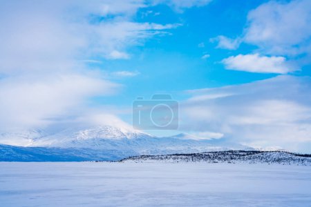 Zugefrorener See Tornetrask und schneebedeckte Berge rund um Abisko, Schweden