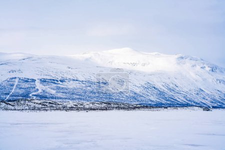 Zugefrorener See Tornetrask und schneebedeckte Berge rund um Abisko, Schweden