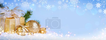 Weihnachten goldene Dekoration und Geschenk isoliert auf blauem Hintergrund.