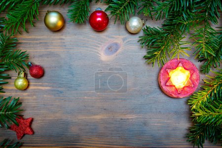 Téléchargez les photos : Branche de sapin avec décorations de Noël et bougie sur vieux fond brun en bois avec espace de copie pour le texte - en image libre de droit