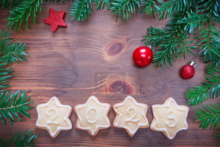 Foto de Año Nuevo 2023 galletas y decoraciones sobre fondo marrón madera vieja con espacio de copia para el texto. - Imagen libre de derechos