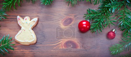 Foto de Rama de abeto con galleta de Navidad y decoraciones sobre fondo marrón madera vieja con espacio de copia para texto. - Imagen libre de derechos