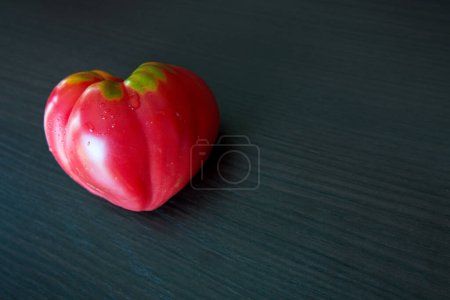 Photo for Red tomato in shape of heart on brown background - Royalty Free Image