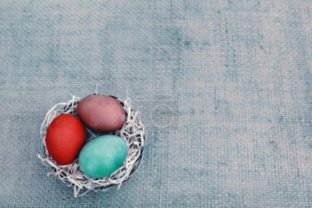 Foto de Huevos coloridos de Pascua sobre fondo de tela gris. Tarjeta de felicitación pring
. - Imagen libre de derechos