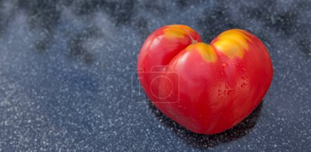 Téléchargez les photos : Red tomato in shape of heart on gray background - en image libre de droit