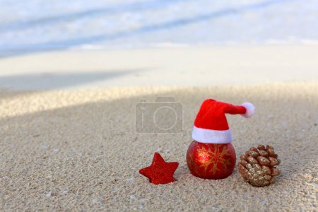 Foto de Feliz bola de Navidad y decoraciones en la blanca arena del Caribe. - Imagen libre de derechos