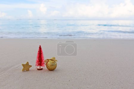 Foto de Feliz bola de Navidad y decoraciones en la blanca arena del Caribe. - Imagen libre de derechos