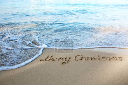 Foto de Feliz Navidad caligrafía en la arena blanca del Caribe . - Imagen libre de derechos