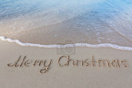 Foto de Feliz Navidad caligrafía en la arena blanca del Caribe . - Imagen libre de derechos